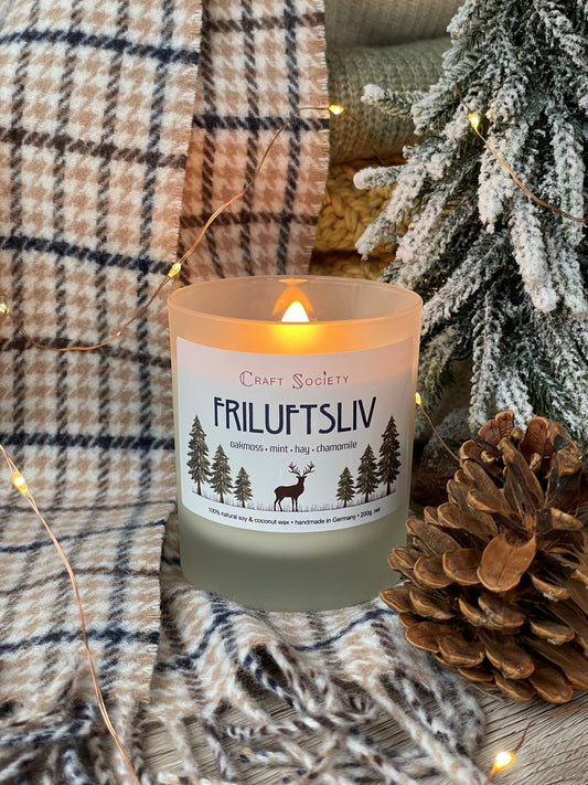 A burning deluxe scented candle made with premium fragrance oils on a decorated background