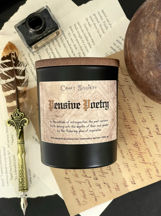 The Pensive Poetry scented candle from above on a decorated background of dark academia