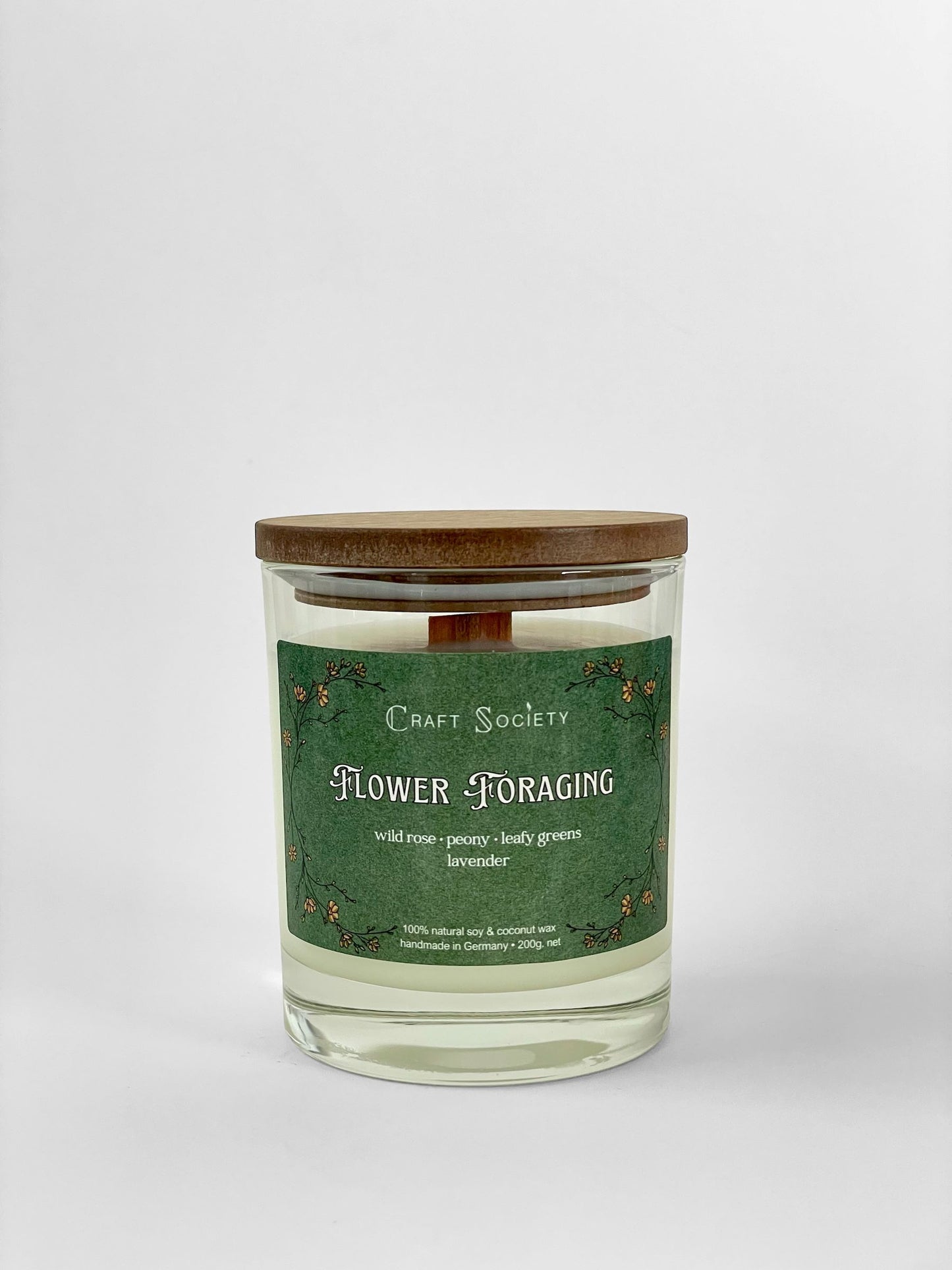 A scented candle called Flower Foraging on a white background, boxed, clear glass jar, deluxe version with wooden wick