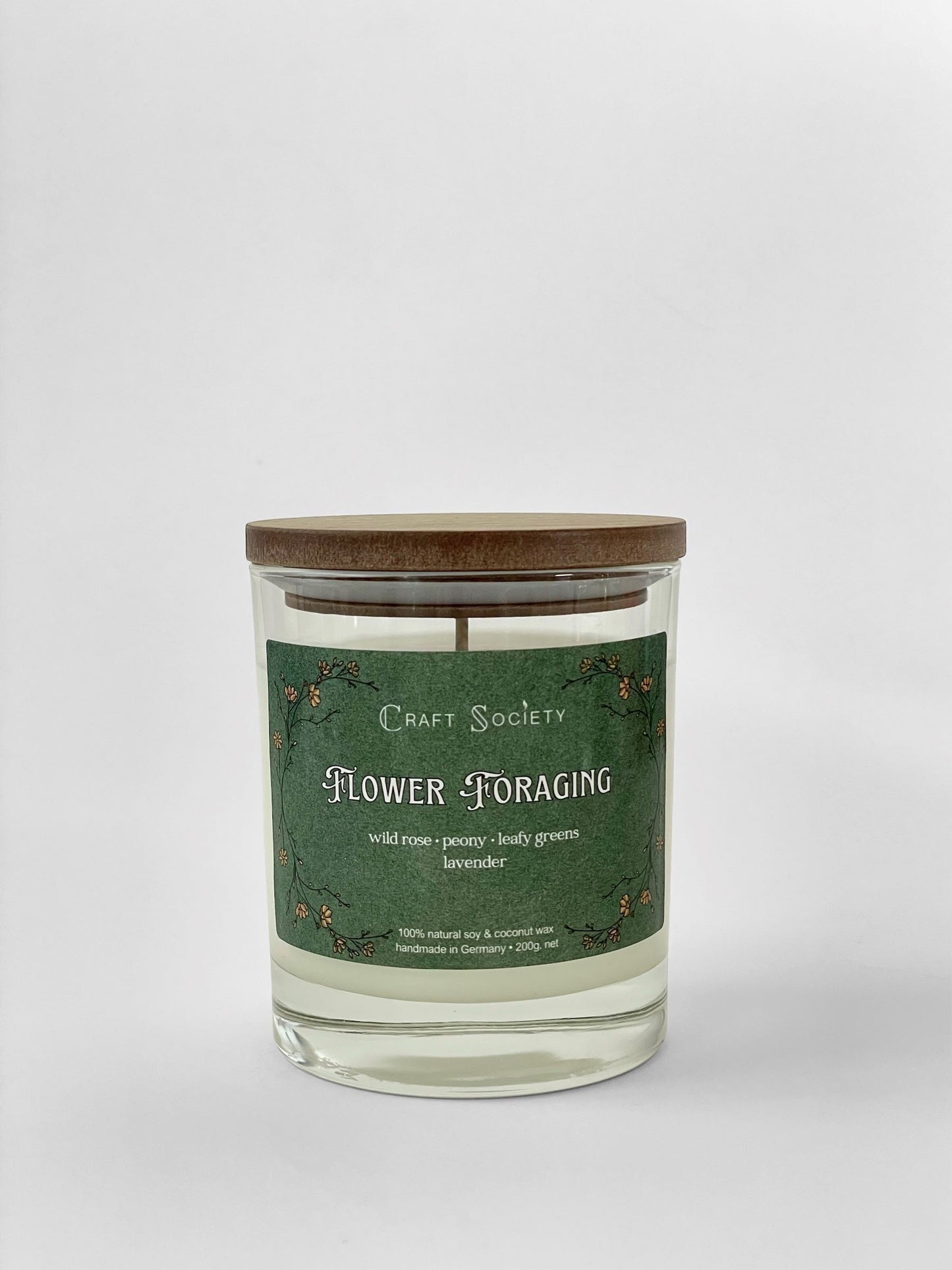 A scented candle called Flower Foraging on a white background, boxed, clear glass jar, regular version with cotton wick