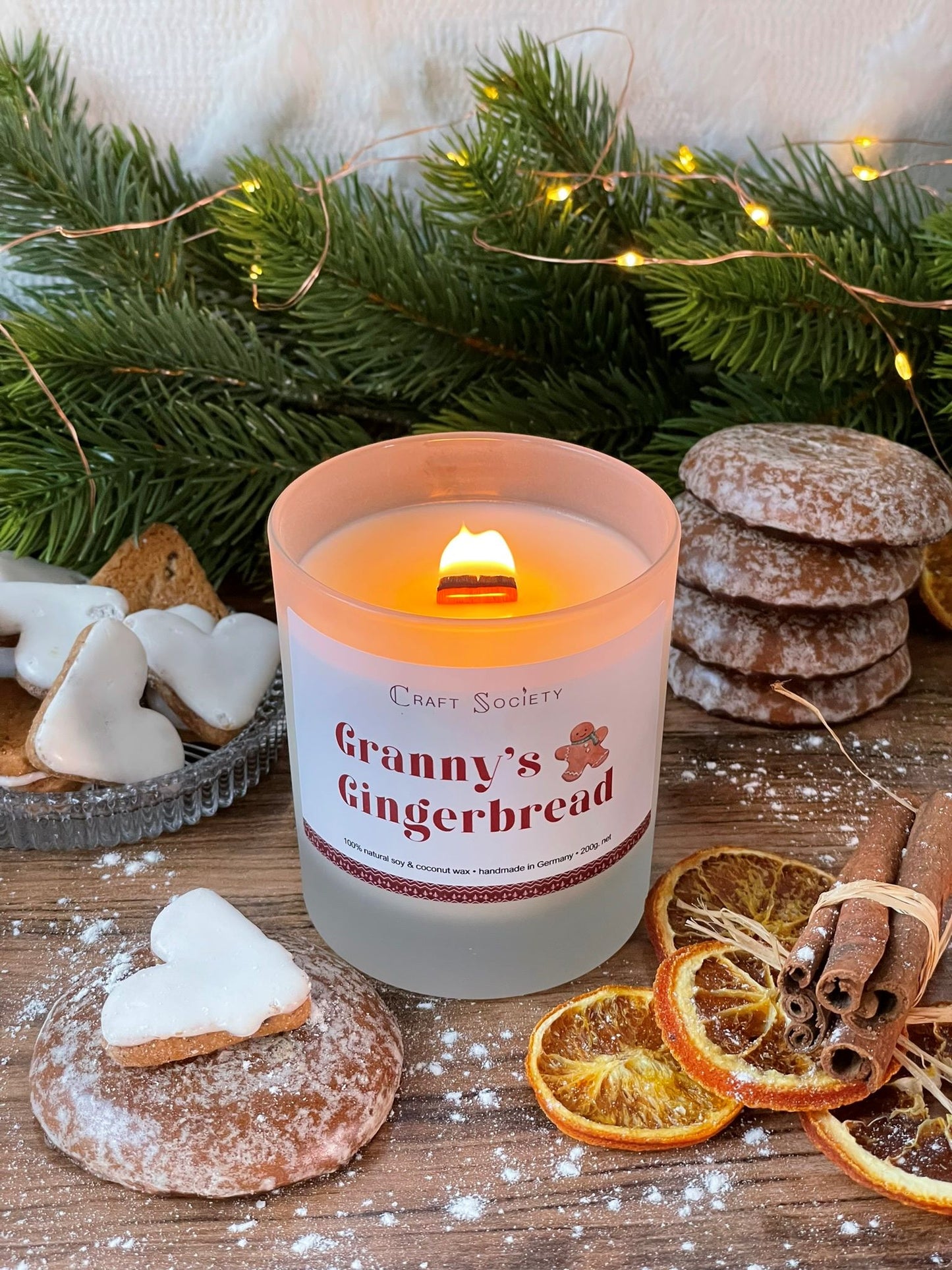 A burning deluxe scented candle on a decorated background