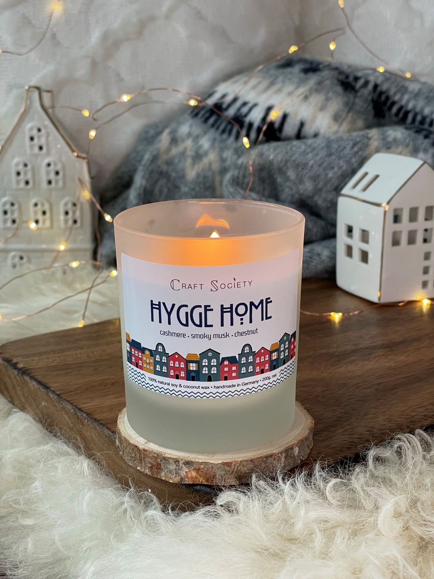 A lit deluxe scented candle made from vegetable wax on a decorated background