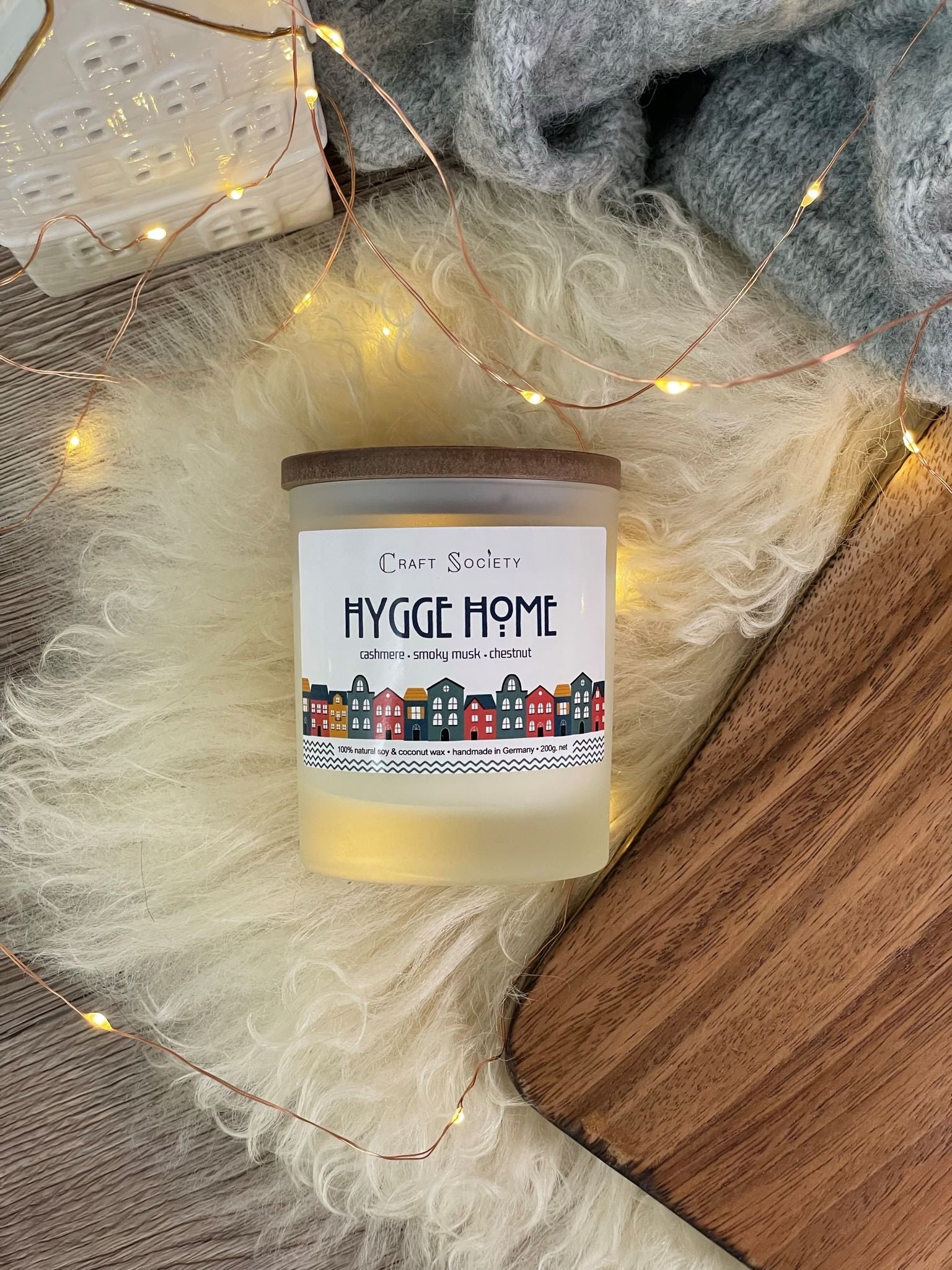 The Hygge Home scented candle with wooden wick from above on a festive background