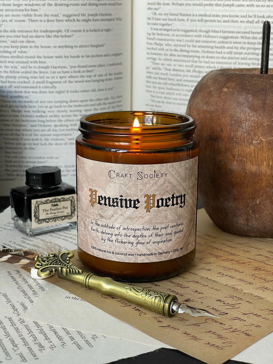 A burning scented candle with an amber jar on a dark academia background