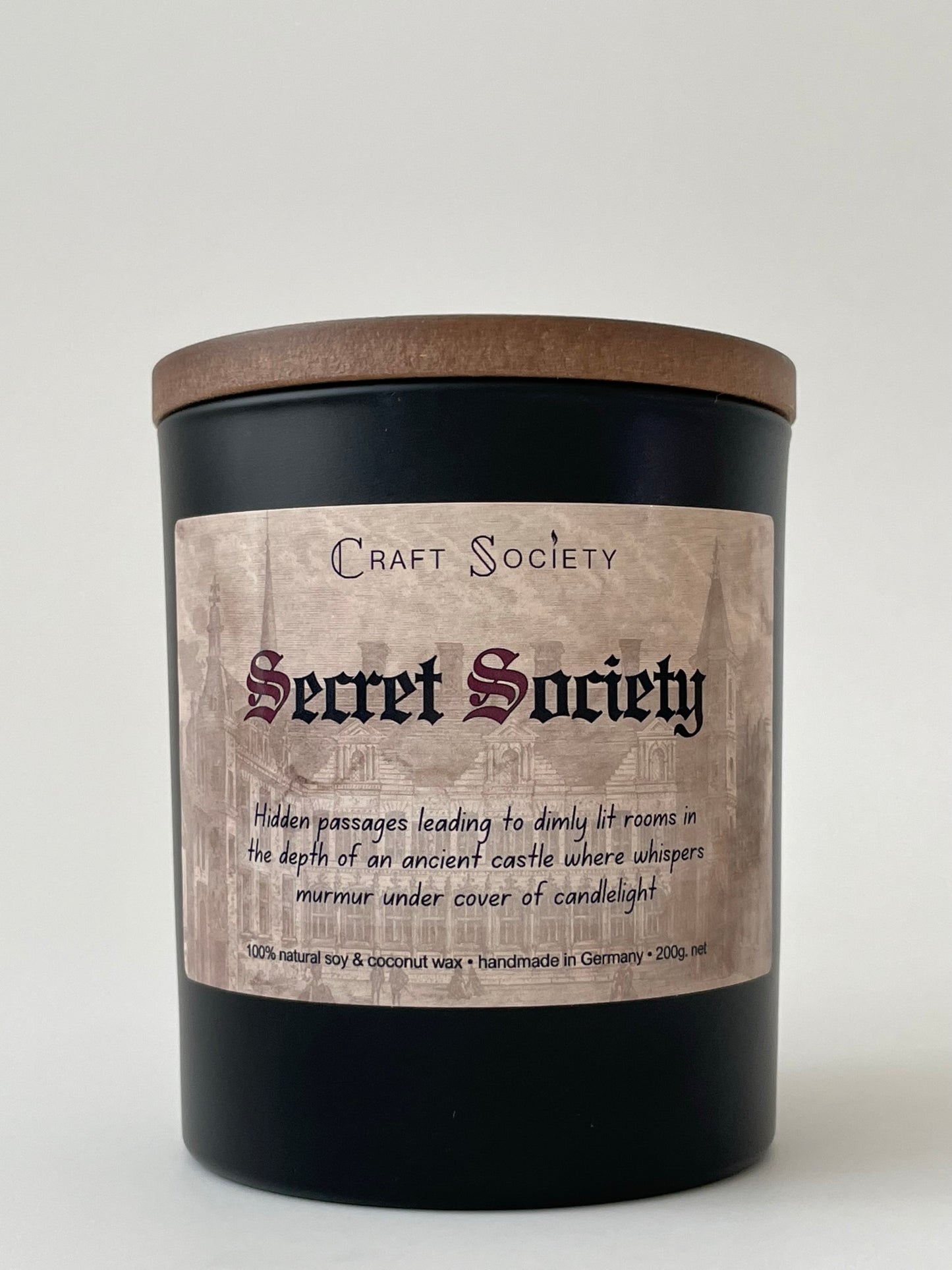 A brand new deluxe scented candle, black jar, on a gray background