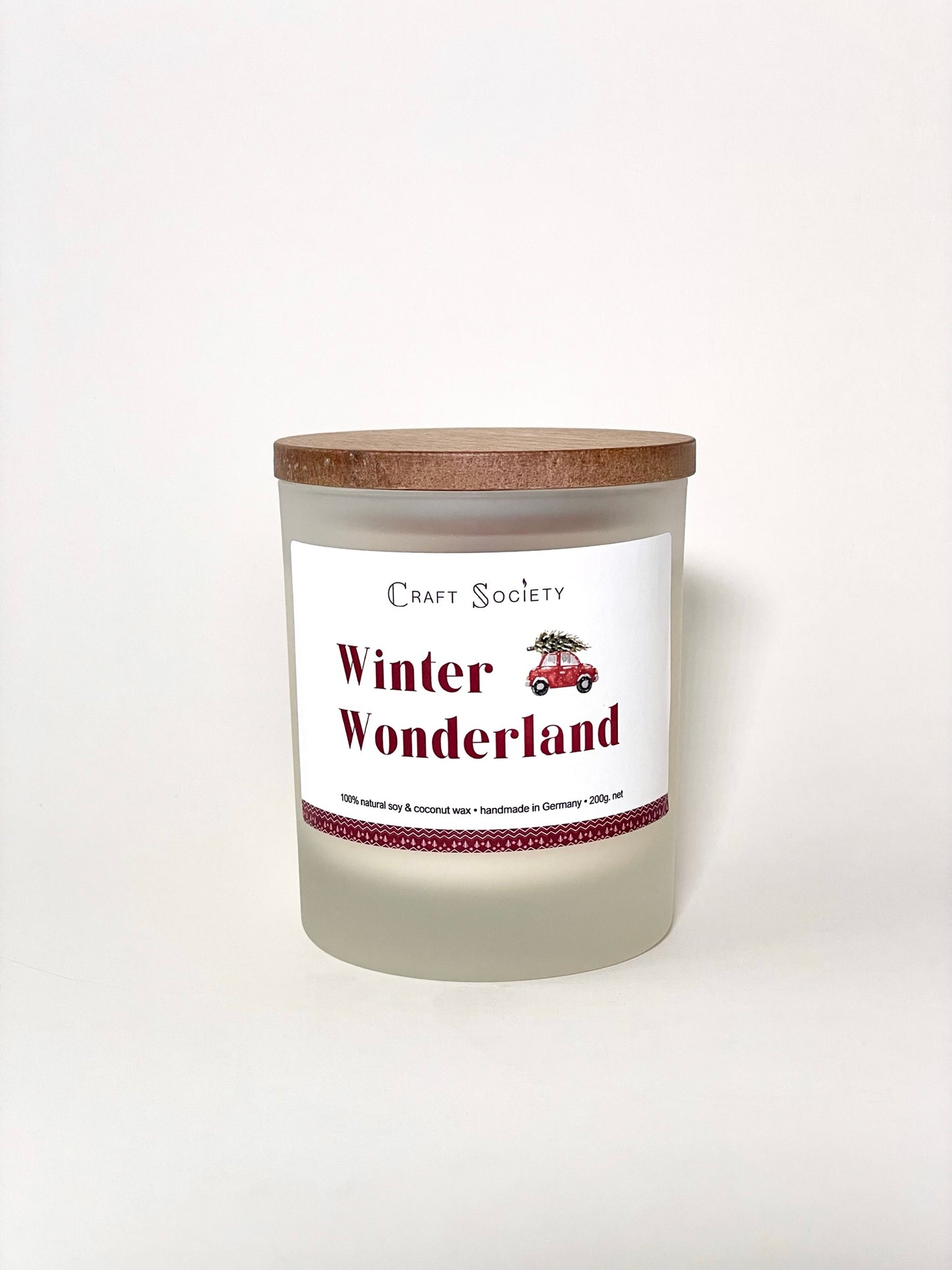 A brand new deluxe scented candle in a frosted jar on a white background