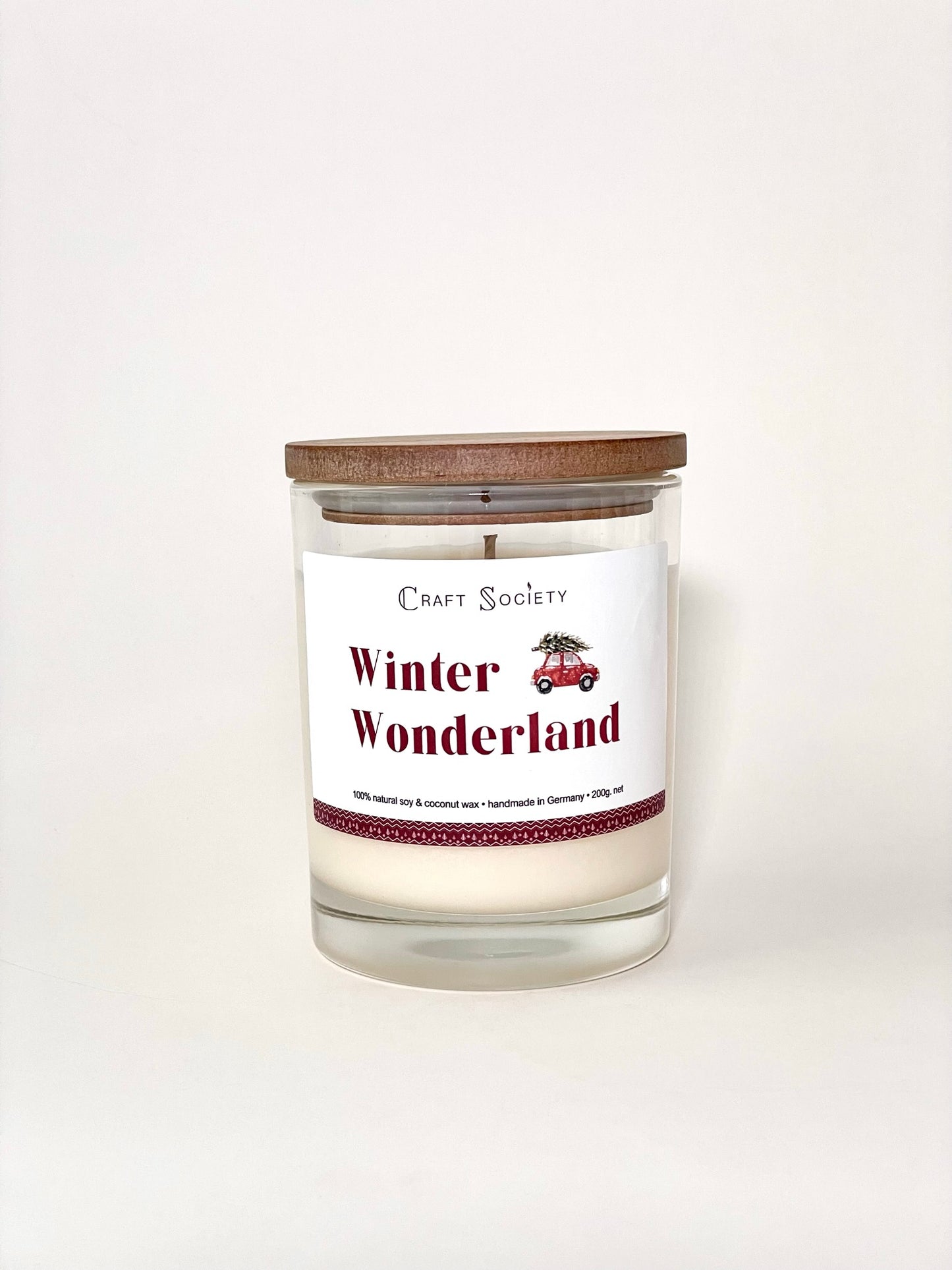 A brand new scented candle in a clear jar on a white background