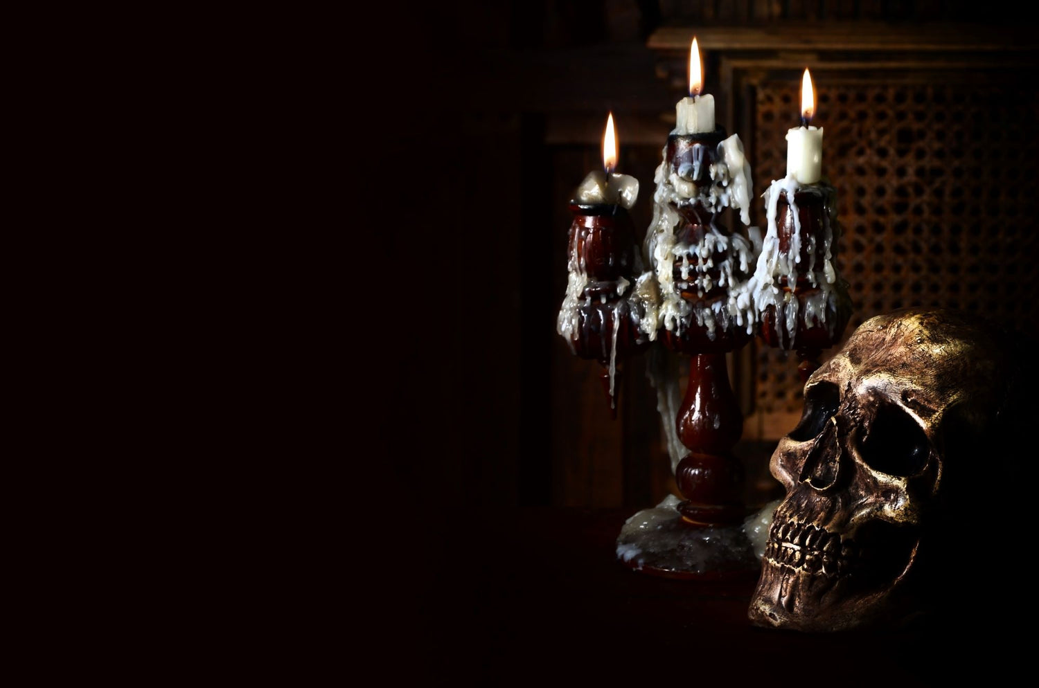 A goth inspired scene on a dark background with a skull and candles